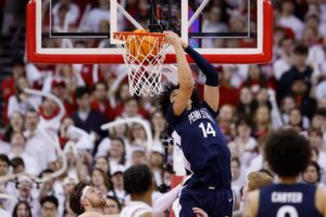 Penn State v Wisconsin - Oddstrader Yanic Konan Niederhauser #14 of the Penn State Nittany Lions scores on a reverse dunk against the Wisconsin Badgers.