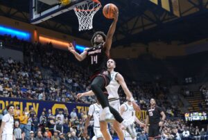 The cover for this college basketball picks today article shows Adrian Wooley #14 of the Louisville Cardinals going in for a layup against the California Golden Bears.