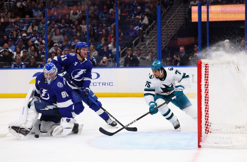 The cover for this NHL picks today article shows Andrei Vasilevskiy #88 of the Tampa Bay Lightning making a third-period save against Ryan Reaves #75 of the San Jose Sharks.
