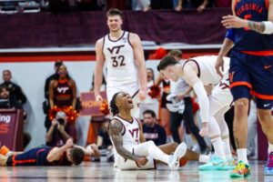 The cover for this college basketball picks today article shows Ben Hammond #3 reacting with Neoklis Avdalas #17 of the Virginia Tech Hokies in overtime against the Virginia Cavaliers.