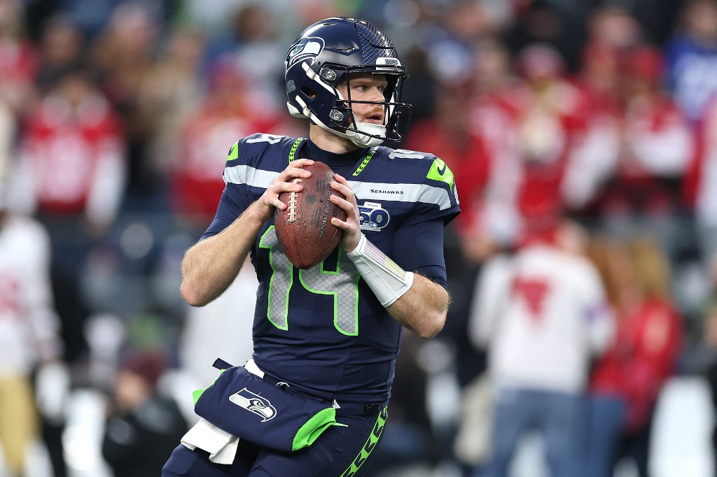 The cover for this NFL championship round picks article shows Sam Darnold #14 of the Seattle Seahawks warming up prior to the NFC Divisional Playoff game against the San Francisco 49ers.