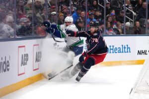 The cover for this NHL picks today article shows David Kampf #64 of the Vancouver Canucks battling Damon Severson #78 of the Columbus Blue Jackets for the puck.