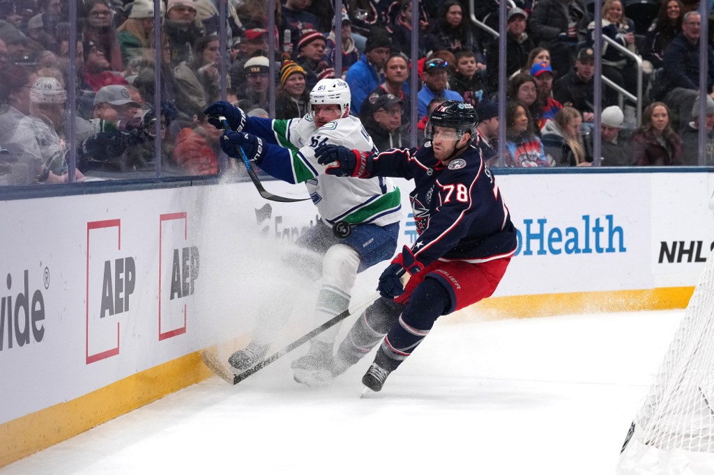 The cover for this NHL picks today article shows David Kampf #64 of the Vancouver Canucks battling Damon Severson #78 of the Columbus Blue Jackets for the puck.