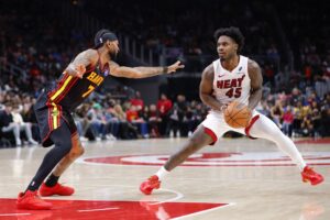 The cover for this NBA player props today article shows Davion Mitchell #45 of the Miami Heat stepping back on Nickeil Alexander-Walker #7 of the Atlanta Hawks.