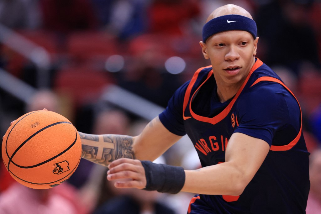 The cover for this college basketball picks today article shows Jacari White #6 of the Virginia Cavaliers driving to the basket during the first half against the Louisville Cardinals.
