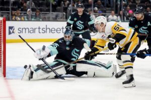 The cover for this NHL picks today article shows Noel Acciari #55 of the Pittsburgh Penguins shooting against Joey Daccord #35 of the Seattle Kraken.