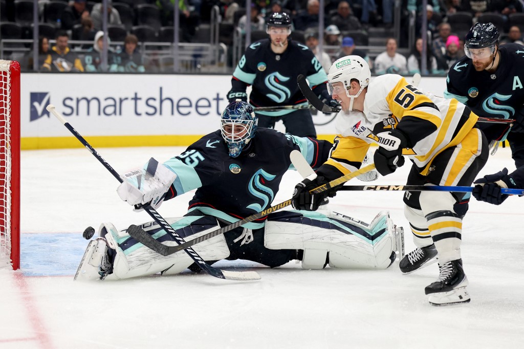 The cover for this NHL picks today article shows Noel Acciari #55 of the Pittsburgh Penguins shooting against Joey Daccord #35 of the Seattle Kraken.
