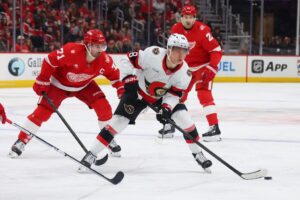 Ottawa Senators v Detroit Red Wings - Oddstrader The cover for this NHL picks today article shows Tim Stützle #18 of the Ottawa Senators controlling the puck in front of Dylan Larkin #71 of the Detroit Red Wings.