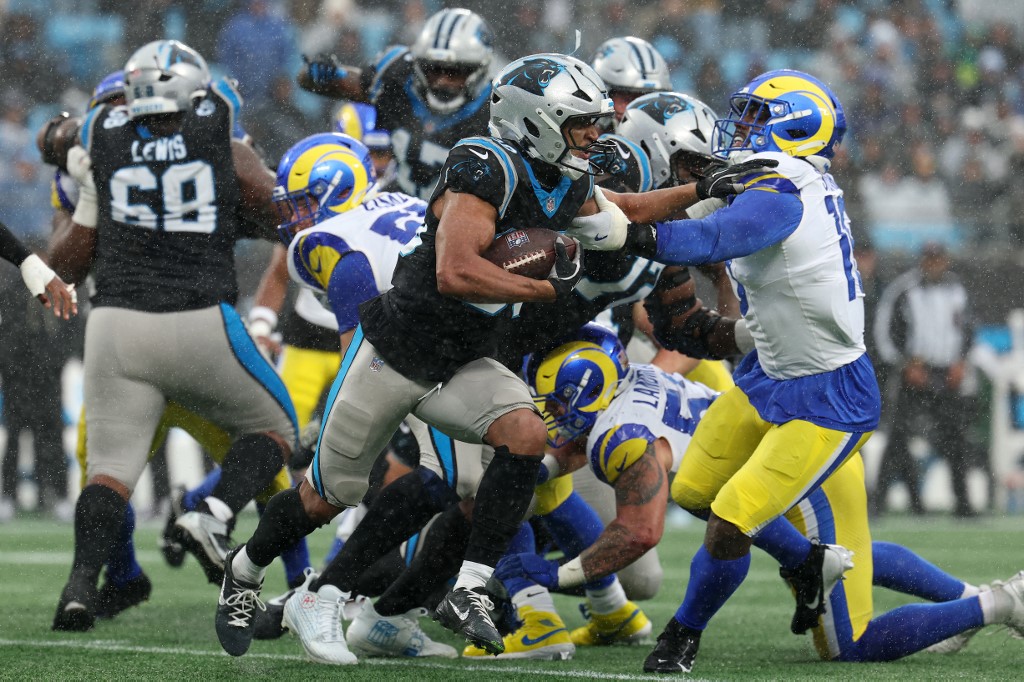 Chuba Hubbard #30 of the Carolina Panthers stiff arms Josaiah Stewart #10 of the Los Angeles Rams.