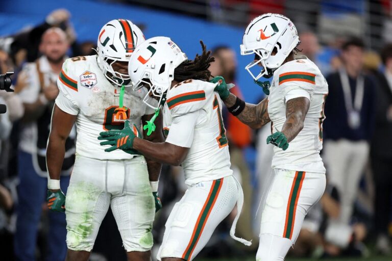 College Football Playoff Semifinal - Vrbo Fiesta Bowl Miami v Ole Miss - Oddstrader - Oddstrader Malachi Toney #10 of the Miami Hurricanes (C) celebrates his touchdown with running back Charmar Brown #6 and Keelan Marion #0 during the 2025 College Football Playoff Semifinal at the VRBO Fiesta Bowl against the Ole Miss Rebels.
