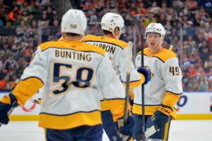 Michael Bunting #58, Michael McCarron #47 and Reid Schaefer #49 of the Nashville Predators celebrate a third-period goal against the Edmonton Oilers.