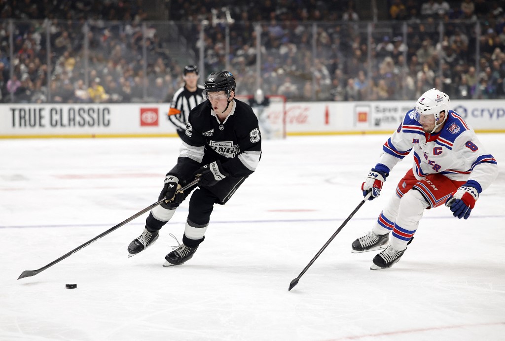 The cover for this NHL picks today article shows Brandt Clarke #92 of the Los Angeles Kings skates the puck against J.T. Miller #8 of the New York Rangers in the second period.