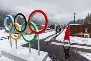 The cover for this Olympics hockey odds article shows a member of Team Germany walking past the Olympic rings at the Olympic Village ahead of the Milano Cortina 2026 Winter Olympics.