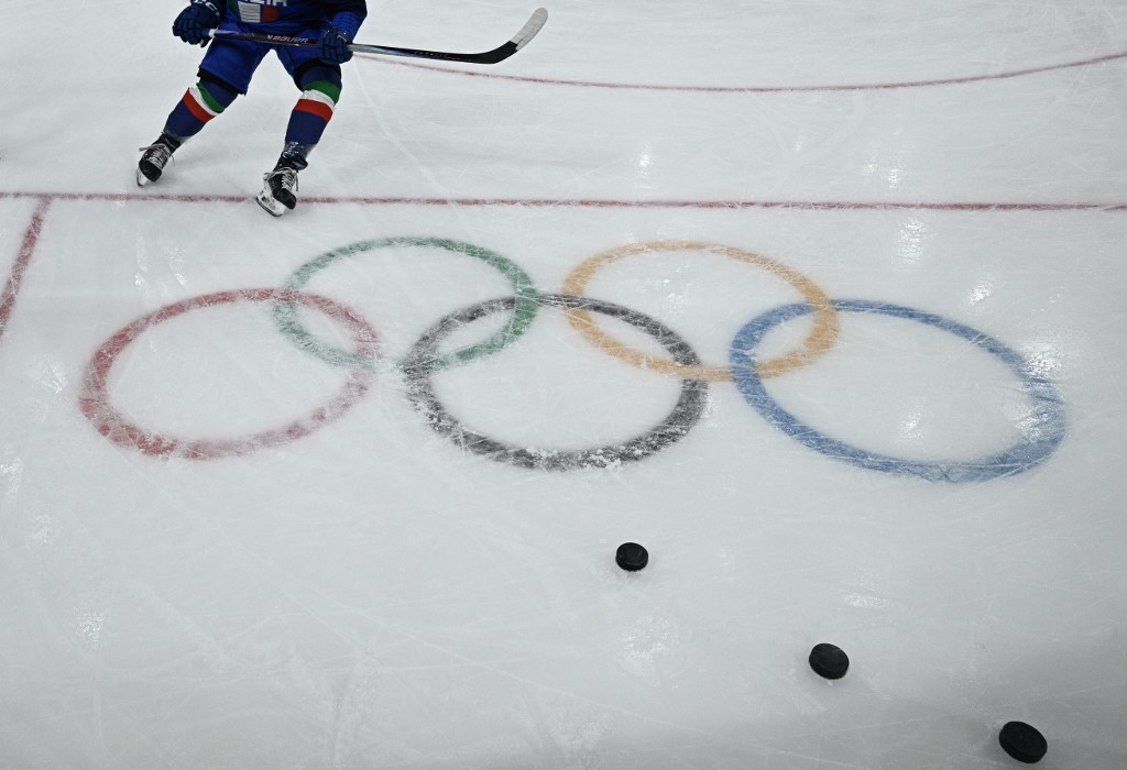 Olympic rings adorn the ice rink as players warm up prior to the an Ice Hockey match during the Milano Cortina 2026 Winter Olympic Games.