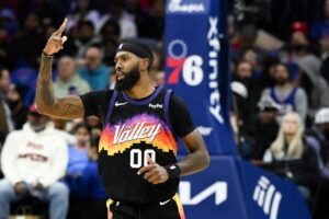 The cover for this NBA player props today article shows Royce O'Neale #00 of the Phoenix Suns celebrating scoring a three-pointer during the second half.