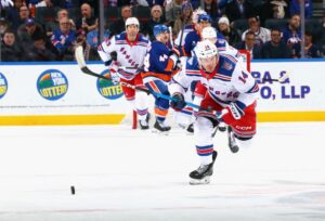 The cover for this NHL picks today article shows Taylor Raddysh #14 of the New York Rangers skating against the New York Islanders.